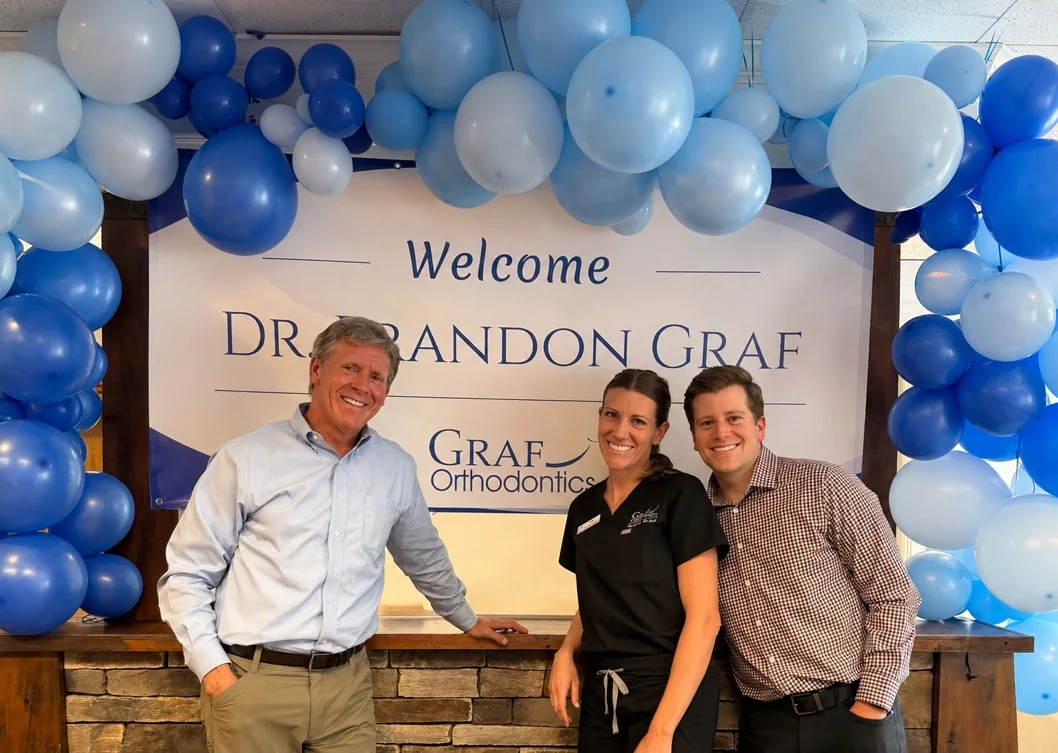 Dr. Brian Graf, Angie, and Dr. Brandon Graf welcoming Dr. Brandon home to Graf Orthodontics