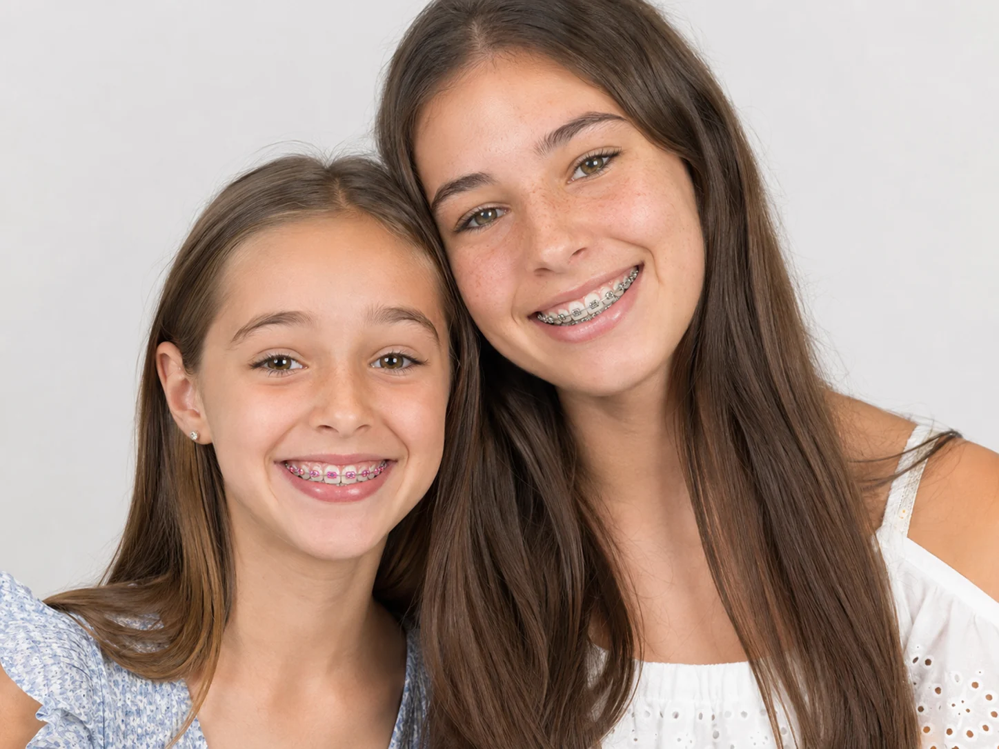 Two smiling Graf Orthodontics patients wearing braces